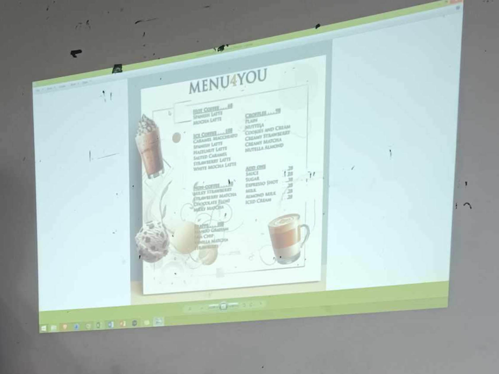 Projected cafe menu photographed on a wall, showing faded drink and dessert listings with images and prices.